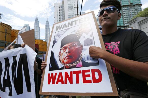 A protester holds a poster of Filipino Sultan Jamalul Kiram III during a protest outside the Philippine Embassy in Kuala Lumpur, Malaysia.