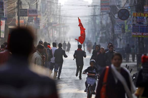 Members of the splinter faction of the Unified Communist Party of Nepal Maoist shout slogans against the government and run through a street during a general strike in Katmandu.