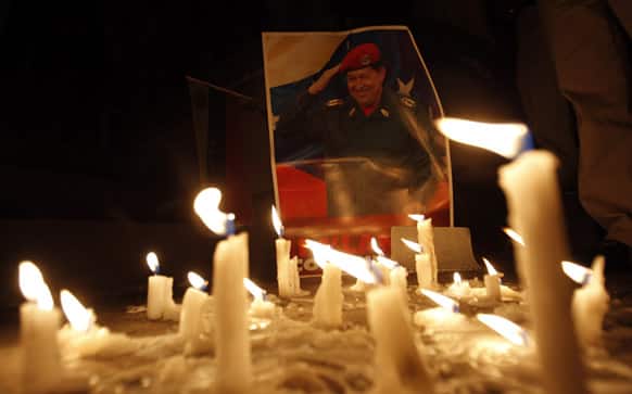 Candles, placed by mourner demonstrators, burn in front of an image of Venezuela`s President Hugo Chavez outside Venezuela`s embassy in Quito, Ecuador. Venezuela`s Vice President Nicolas Maduro announced that Chavez died on Tuesday at age 58 after a nearly two-year bout with cancer.