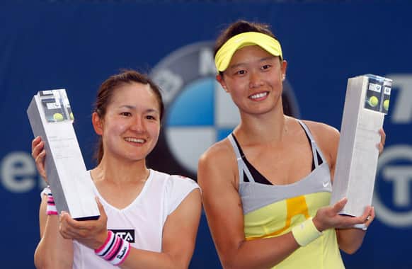 Chang Kai-chen, right, of Taiwan, and Shuko Aoyama of Japan pose with their trophies after defeating Janette Husarova of Slovakia and Zhang Shuai of China in their doubles final match at the WTA Malaysian Open tennis tournament.