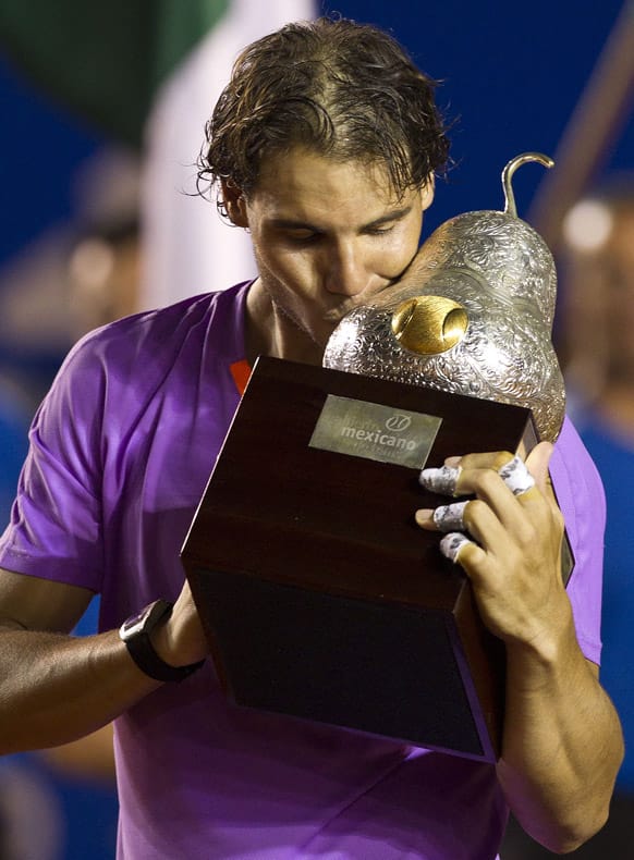 Spain´s Rafael Nadal kisses the trophy for the cameras after beating Spain`s David Ferrer in the final round match of the Mexico Open tennis tournament in Acapulco, Mexico.
