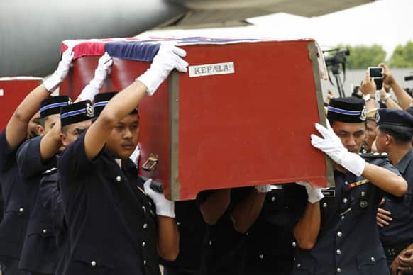 Malaysian police officers carry the coffins of two commandoes who were killed in a mortar attack after a exchange of fire between Malaysian security forces and the Sulu sultanate intruders as they arrives at the Royal Malaysian Air Force base in Subang, Malaysia.