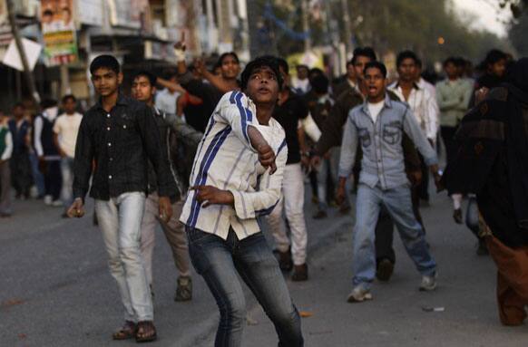 Protesters hurl stones towards police officers during a protest against the rape of a 7-year-old girl in New Delhi.
