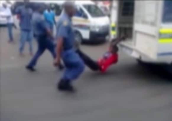 In this still frame from TV and courtesy of South African Daily Sun newspaper, showing a South African man with his hands tethered to the back of a police vehicle being dragged behind as police hold his legs up and the vehicle apparently drives off, east of Johannesburg.