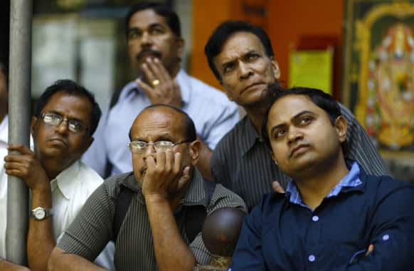 People watch a display screen on the facade of the the Bombay Stock Exchange building in Mumbai. Finance minister Thursday unveiled a national budget with a promise to put Asia`s third largest economy back on a path of high growth and to check runaway inflation and the fiscal deficit.