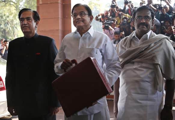 Finance Minister Palaniappan Chidambaram, center, arrives with his aides at the Indian Parliament to present the annual budget in New Delhi.