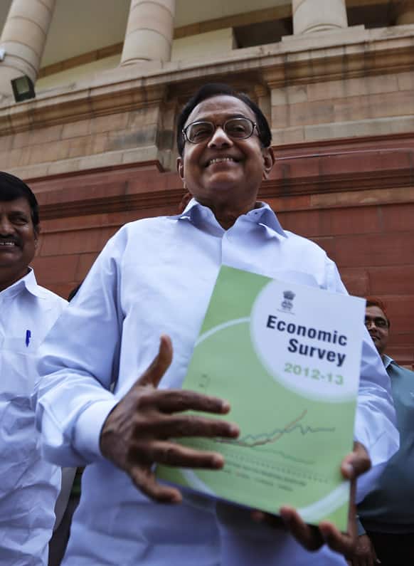 Finance Minister Palaniappan Chidambaram comes out of the Indian Parliament with a copy of the economic survey in New Delhi.