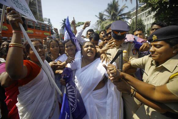 Activists of the Republic Party of India shout slogans protesting against the rape and killing of three young sisters in Maharashtra state as police detain them outside the state government administrative headquarters in Mumbai.