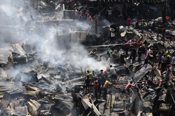 Bangladeshi firefighters and volunteers work to douse a fire at the Kallyanpur Natun Bazar slum in Dhaka. According to police, at least 300 shanties were gutted but there were no casualties.