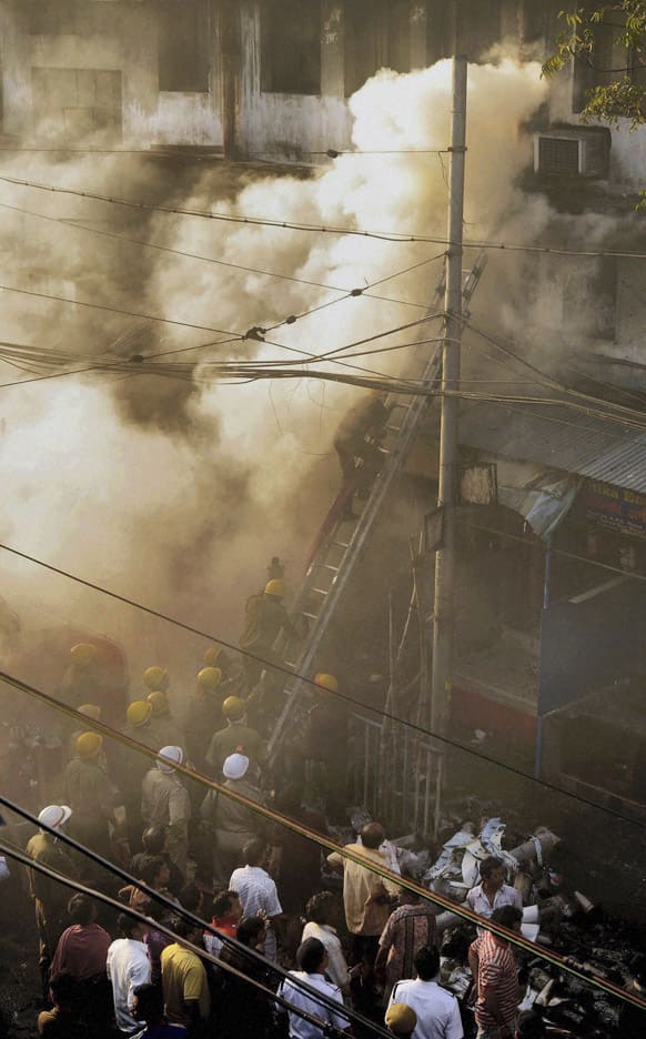 Firemen try to douse a fire that broke out early in the morning at an illegal six-story plastics market in Kolkata.