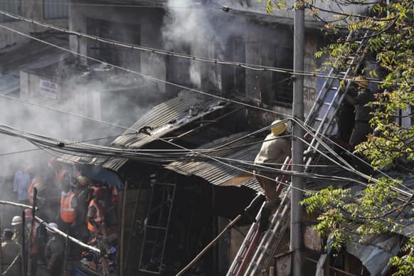 Firemen try to douse a fire that broke out early in the morning at an illegal six-story plastics market in Kolkata.