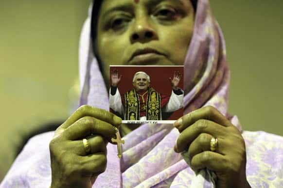 An Indian Catholic woman holds a portrait of Pope Benedict XVI during a special mass for his health at a church in Kolkata.