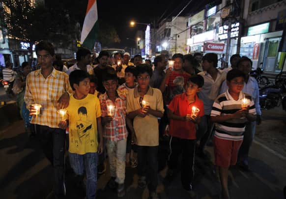Children walk during a candlelight vigil to pay respects to the victims of Thursday`s twin bomb blasts in Hyderabad.