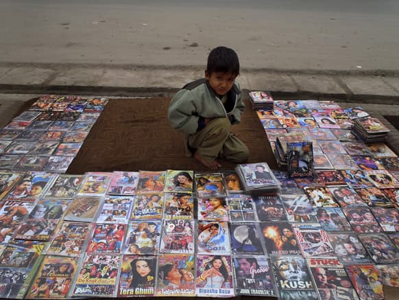 An Afghani boy, Ahmad Shah, 7, displays bootleg movies for sale along a road side in Jalalabad, Afghanistan.