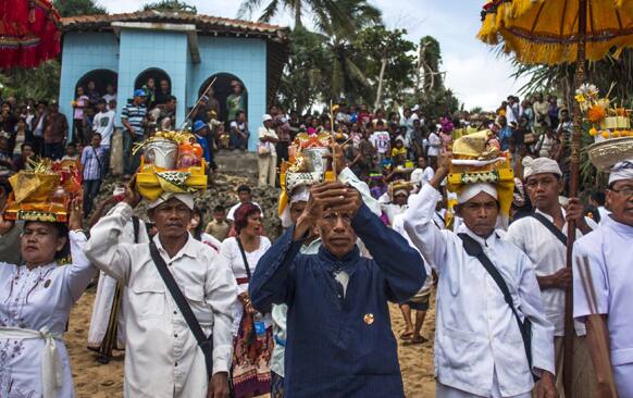 Hindu priests hold offerings during a religious ceremony called Melasti on Ngobaran Beach in Yogyakarta.
