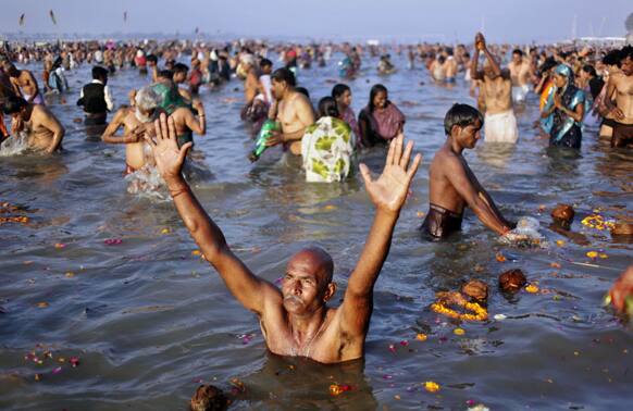 A devotee prays to the Sun God as he takes holy dips at Sangam, the confluence of the Rivers Ganges, Yamuna and mythical Saraswati on Maghi Purnima, or the full-moon day, considered an auspicious bathing day, during the Maha Kumbh festival in Allahabad.