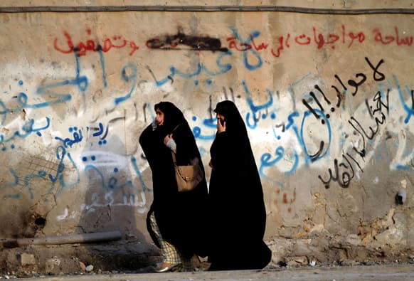 Bahraini women cover their mouths from tear gas during clashes between anti-government protester and riot police in Bani Jamra, Bahrain.