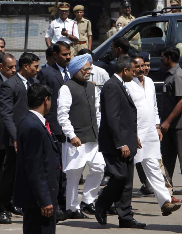 Prime Minister Manmohan Singh, blue turban, accompanied by Andhra Pradesh state Chief Minister N. Kiran Kumar Reddy, right in white, visits Dishuknagar bus station, one of the two sites of Thursday’s bomb attacks in Hyderabad.