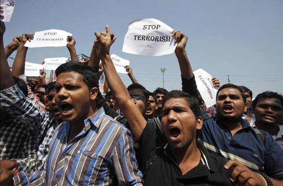 People shout slogans against terrorism at the site of one of the two bomb blasts in Hyderabad.