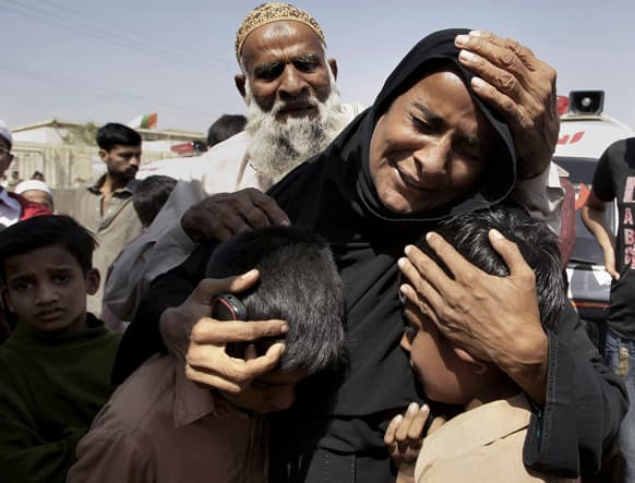 A Pakistani woman, Shahida Parveen, seen comforting her sons, mourns for her husband, Mohammad Akmal, a victim of a Sept. 11, 2012 factory fire incident, during a funeral in Karachi, Pakistan.