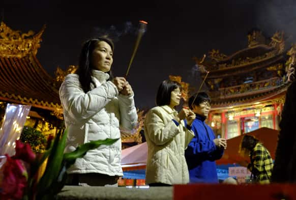 Devotees pray at the Lungshan Temple on the eve of the Chinese lunar new year in Taipei, Taiwan.