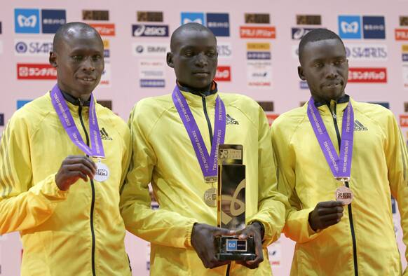 Winner Dennis Kimetto of Kenya, poses with compatriots Michael Kipyego, who placed second and Bernard Kipyego who placed third, after the awards ceremony of the men`s Tokyo Marathon in Tokyo.