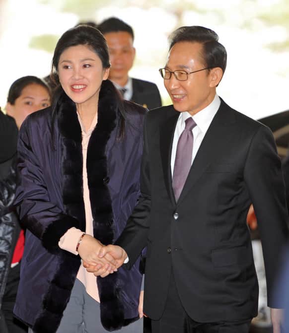 South Korean President Lee Myung-bak, right, greets Thai Prime Minister Yingluck Shinawatra, during her visit to Seoul to attend the inauguration of Lee`s successor, Park Geun-Hye, on Monday.