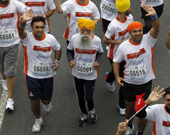 Centenarian marathon runner Fauja Singh, 101, center, originally from Beas Pind, in Jalandhar, India but who now lives in London, runs in a 10-kilometer race, part of the annual Hong Kong Marathon.