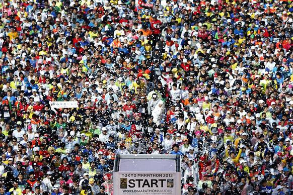 Thousands of runners take their positions under a shower of confetti in front of the Tokyo Metropolitan Government Building at the start of the Tokyo Marathon.