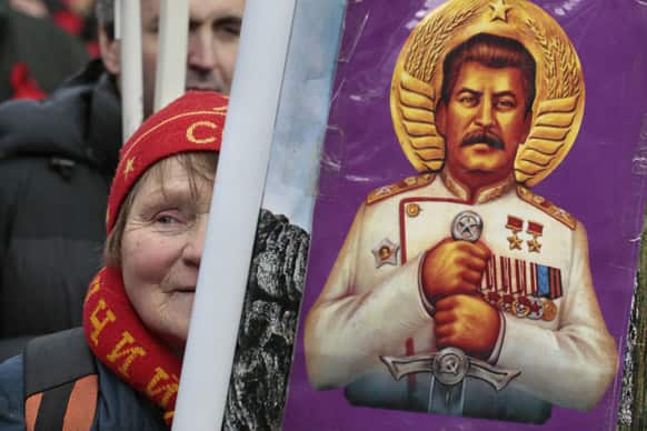 A woman holds a portrait of the Soviet dictator Josef Stalin, during a communists rally to mark Defenders of the Fatherland Day in Moscow, Russia.