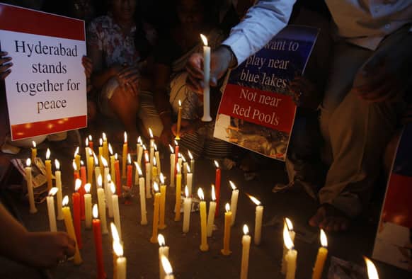 People hold placards during a candlelight vigil at one of the two bomb blast sites, in Hyderabad.