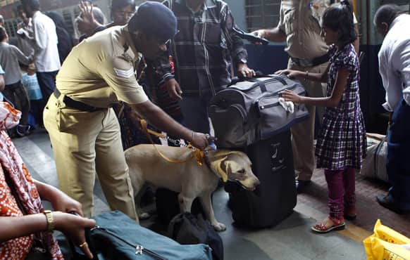 An Indian railway police officer with a sniffer dog inspects the luggage of passengers at a railway station following Thursday’s twin explosions in the southern Indian city of Hyderabad.