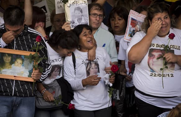 Relatives of the victims of a train crash react during the one-year anniversary ceremony at the Once train station in Buenos Aires, Argentina.
