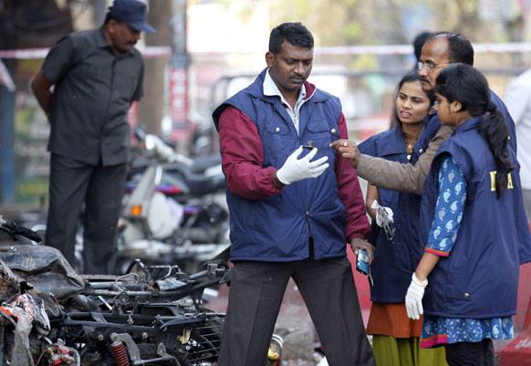National Investigation Agency collect evidence in the debris at one of the two bomb blast sites, in Hyderabad.