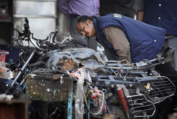 National Investigation Agency looks for evidence in the debris at one of the two bomb blast sites, in Hyderabad.