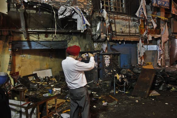 Investigative official takes photographs of the debris at one of the two bomb blast sites, in Hyderabad.