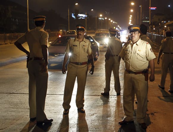 Police officers keep vigil on a road after security was enhanced in Mumbai, following twin explosions in southern Indian city of Hyderabad.