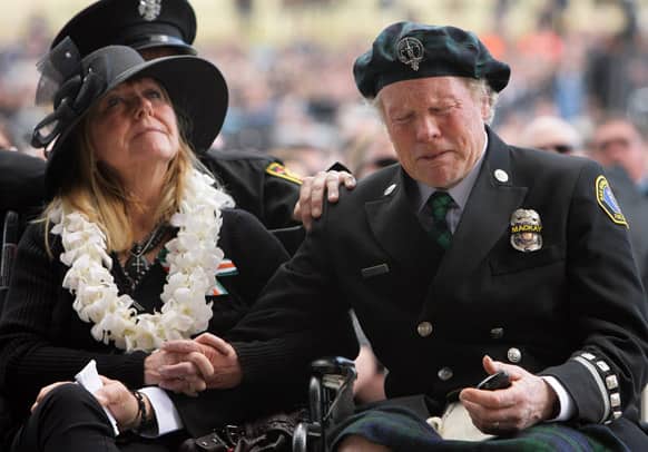 Dawn MacKay sits next to her husband Alan MacKay as he breaks down in tears while watching a video tribute of their son, San Bernardino County Sheriff Det. Jeremiah MacKay at the San Manuel Amphitheater in Glen Helen, Calif.