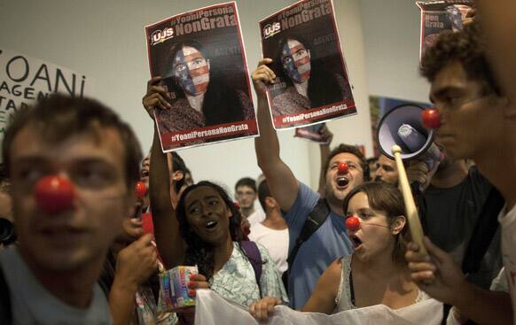 Protesters backing the Cuban government demonstrate against the Cuban blogger Yoani Sanchez outside a bookstore where she promotes her book