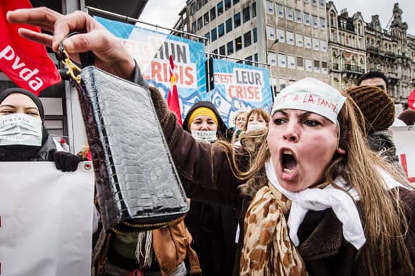 A worker shouts and shows her wallet as she demonstrates together with tens of thousands of workers to protest against austerity measures that have affected their income during the financial crisis and demand labor-boosting initiatives, in Brussels.