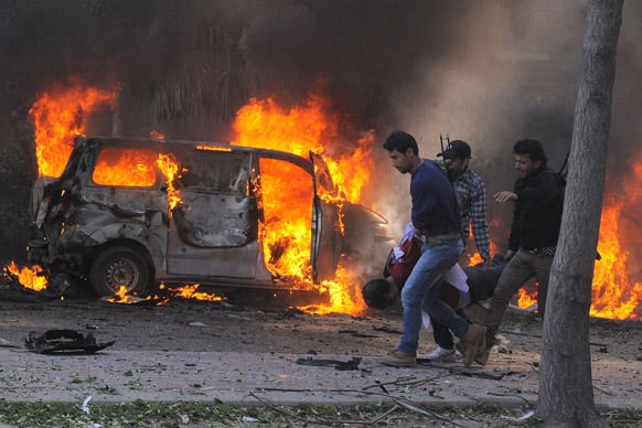 Syrian security agents carrying a body following a huge explosion that shook central Damascus, Syria. A car bomb shook central Damascus on Thursday, exploding near the headquarters of the ruling Baath party and the Russian Embassy.