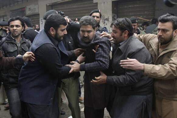 People help a person injured in a blast in Peshawar, Pakistan. Pakistani police said a bomb blast inside a shopping mall in the country`s northwest has killed at least one person and wounded 12 people.