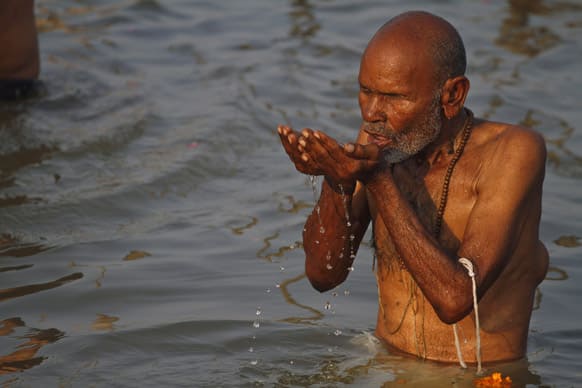 An elderly Hindu devotee drinks water from the Ganges River as he bathes near Sangam, the confluence of Hindu holy rivers of Ganges, Yamuna and the mythical Saraswati, at the Maha Kumbh festival in Allahabad.