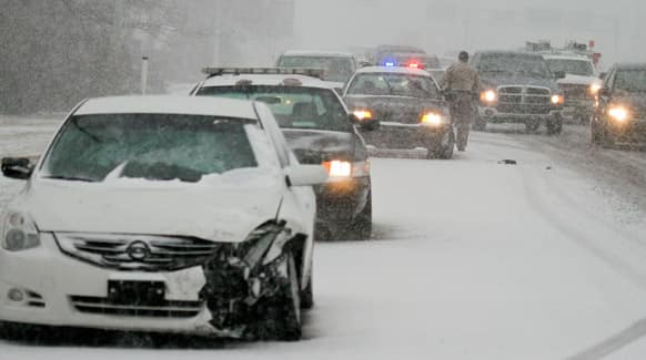 Wichita Police work an accident on west Kellogg during the snow-packed morning commute in Wichita, Kan.