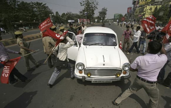 Indian trade union activists of Hind Mazdoor Sabha attack a car that was plying on the first day of a two day strike in Bhubaneswar.