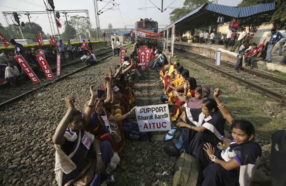 Activists of All India Trade Union Congress (AITUC) shout slogans as they sit on rail tracks to stop trains on the first day of a two day strike in Bhubaneswar.