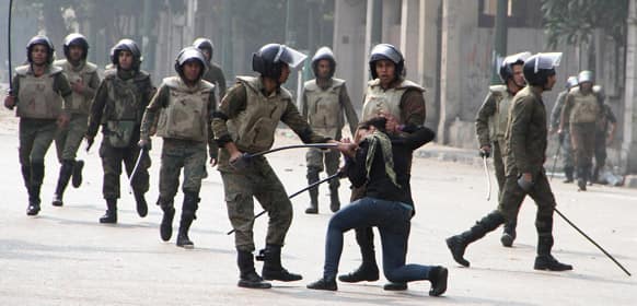 Egyptian army soldiers arrest a woman protester during clashes with military police near Cairo`s downtown Tahrir Square.