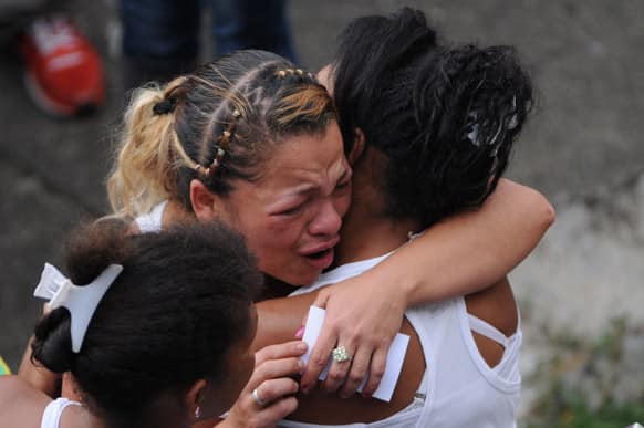 Women embrace during the funeral procession for Esteban Alvarez and Esleider Asprilla, both 11, at the Comuna 13 neighborhood in Medellin, Colombia.