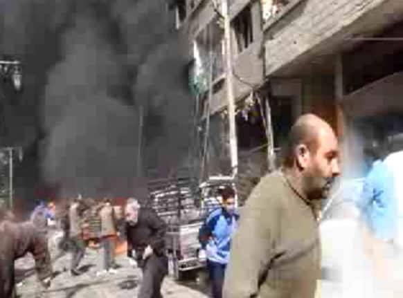 This image taken from video obtained from Ugarit News, which has been authenticated based on its contents and other AP reporting, shows smoke and fire after a fighter jet crashed into a suburb of Damascus, Syria.
