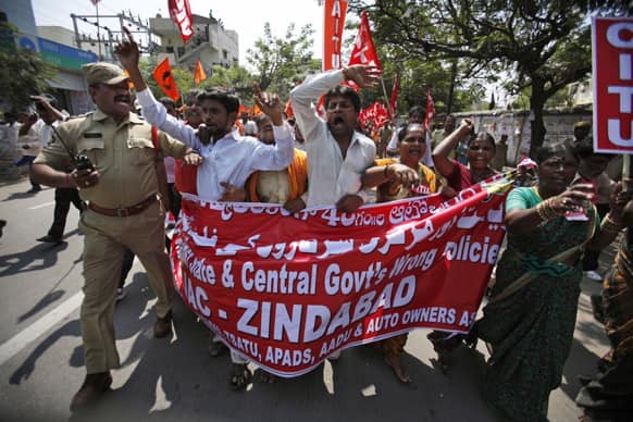 A police officer shouts as he tries to stop workers from marching towards the state legislature complex on the first day of a two day strike in Hyderabad.